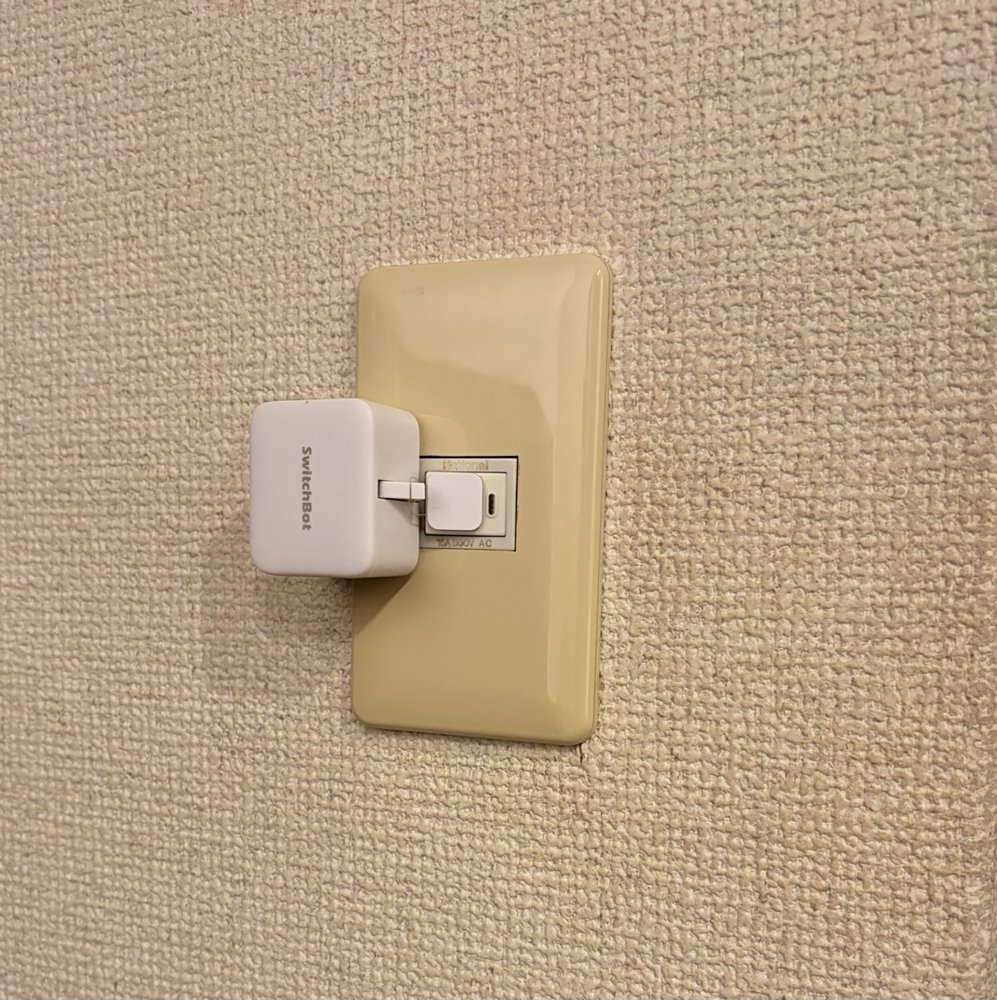 自分の部屋の壁スイッチに取り付けた白いSwitchBotスイッチ