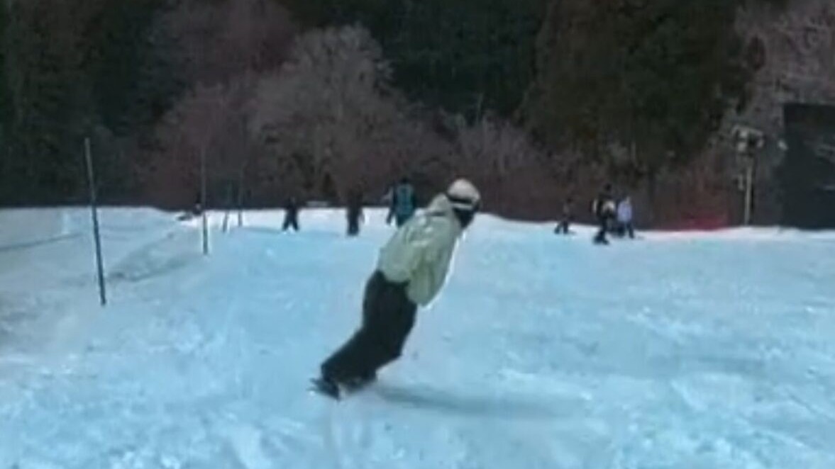 雪山を背景にスノーボードで滑走する様子