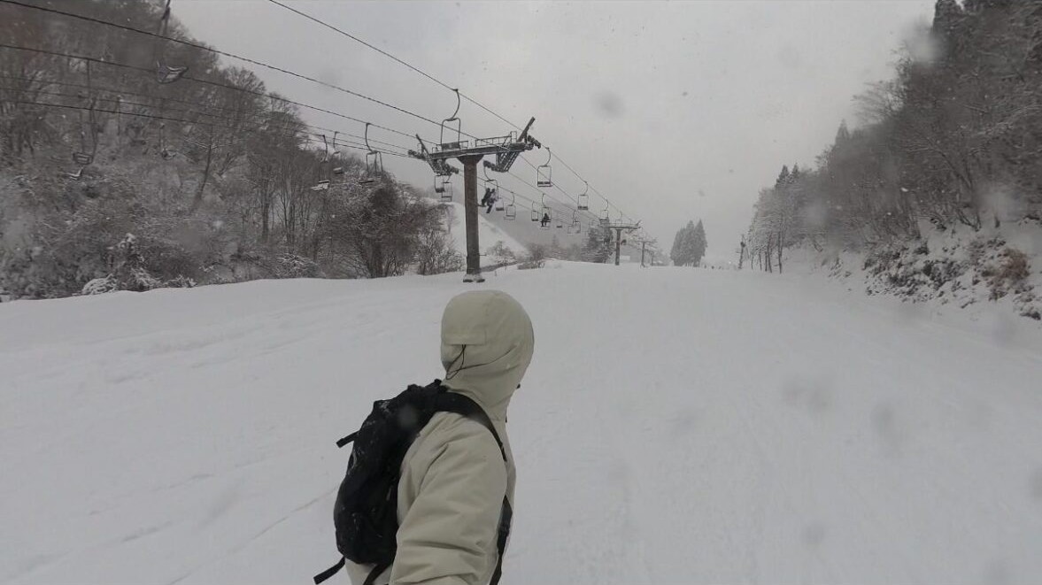 リフト脇の雪道を歩く後ろ姿