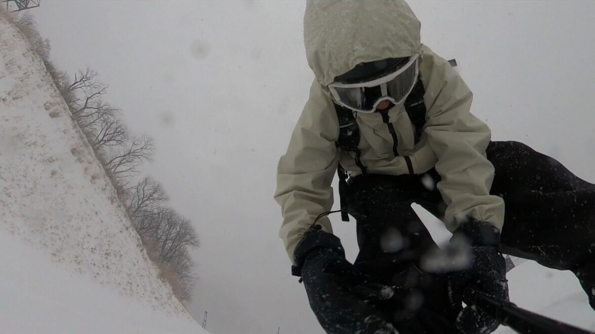 吹雪でホワイトアウトしたゲレンデを滑る様子