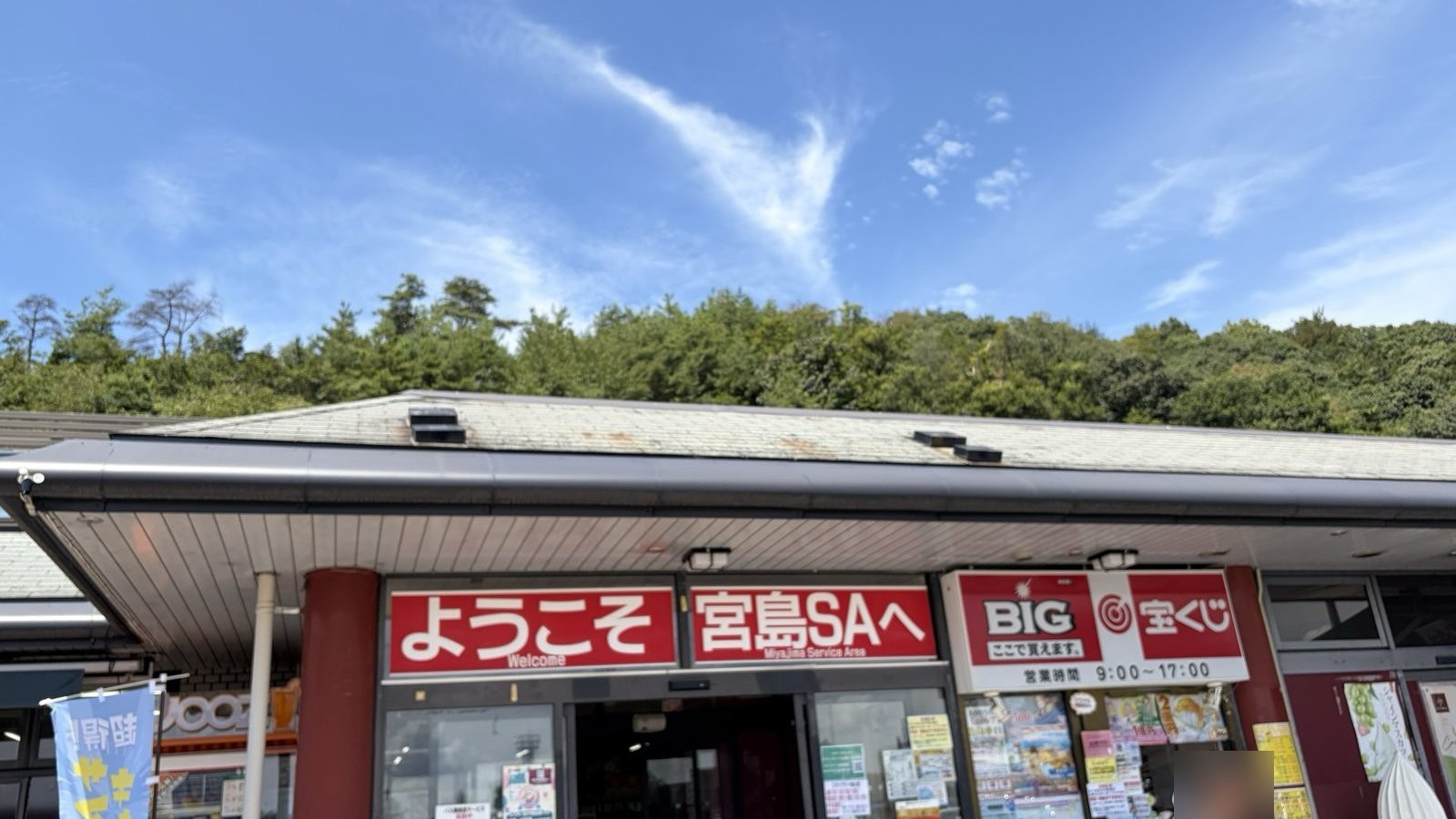 宮島サービスエリアの入口看板。「ようこそ宮島SAへ」の赤い看板と青空が写っている