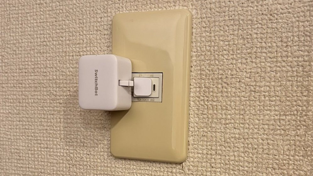 自分の部屋の壁スイッチに取り付けた白いSwitchBotスイッチ