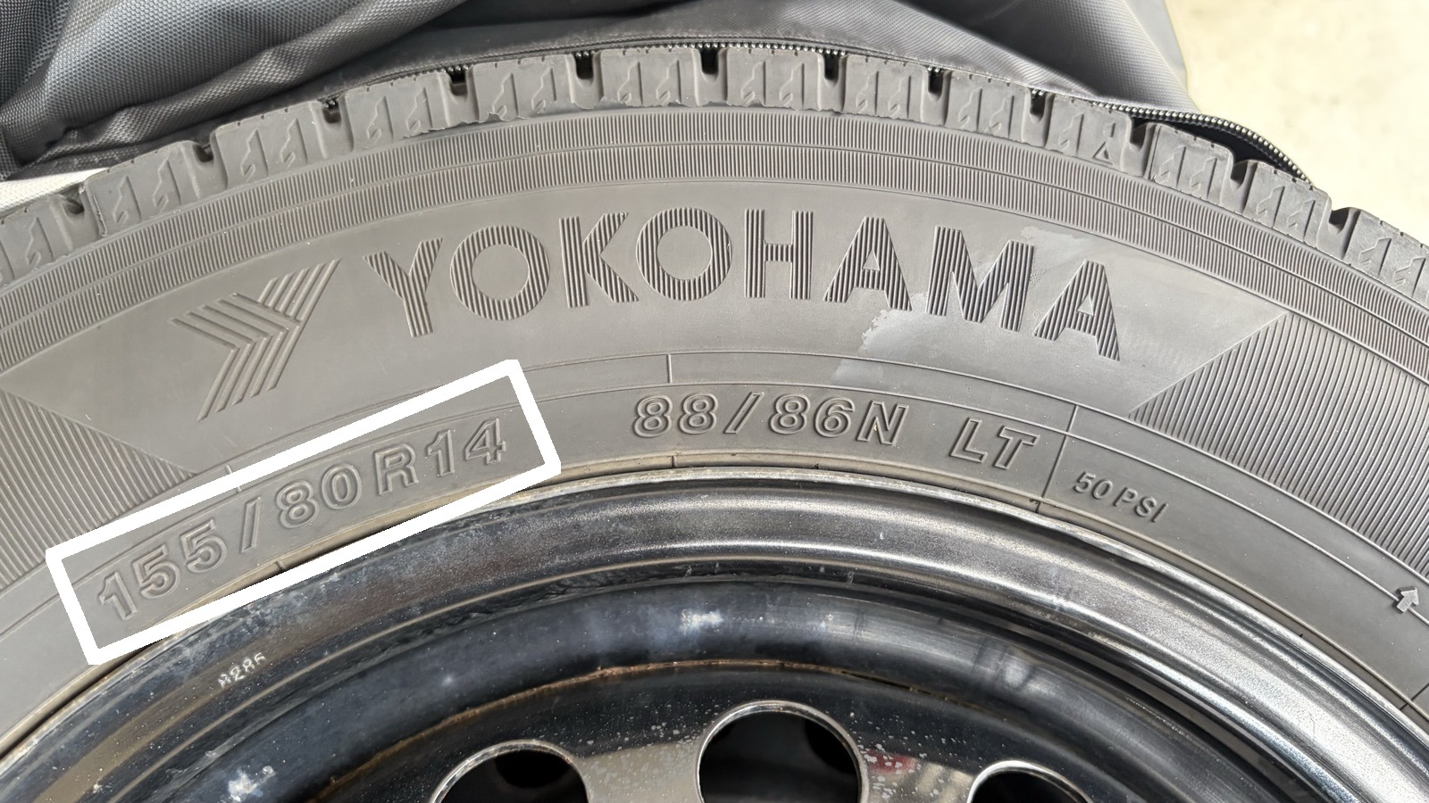 スタッドレスタイヤのサイドウォールに刻印された「155/80R14」というタイヤサイズ表記（白い枠で囲んだ部分）